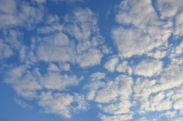 Bright blue sky with cluster of white fluffy clouds. Nature, environment, beautiful sky landscape.