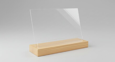 Clear acrylic sign holder atop a light wood base positioned on a pale grey surface