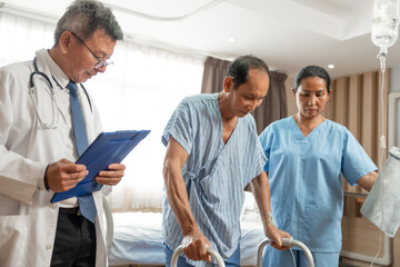 Asian doctor helps an elderly man use a walker mobility support at hospital