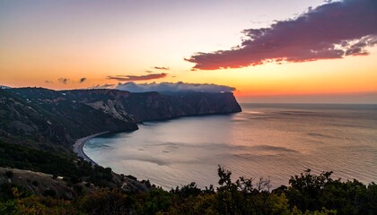 A breathtaking coastal vista at sunset, showcasing a dramatic cliffside, tranquil bay, and vibrant sky.