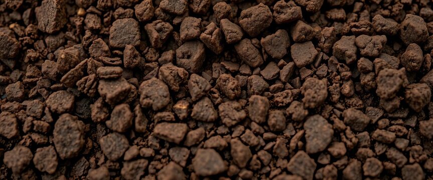 Close-up of rich, dark brown soil with visible crumb structure, silt, soil erosion