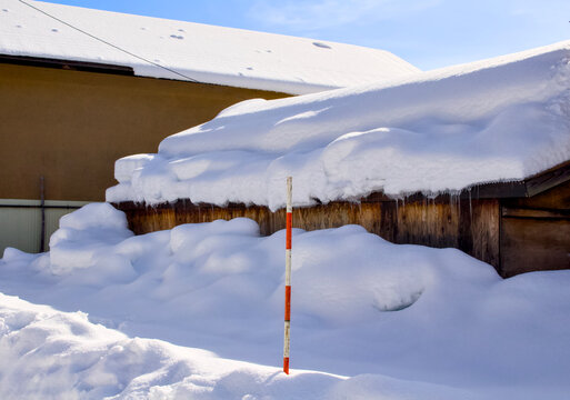 豪雪地帯に設置されている赤と白のスノーポール