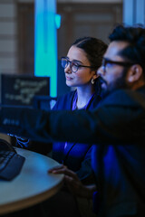 A diverse team of AI developers shares a successful moment in the office. A female programmer...