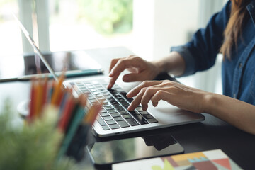 Architecture and interior design concept. Business woman architect working on laptop for creating interior design project in studio office. Freelancer woman working in a modern office, close up