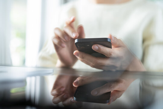 Closeup, woman using smartphone and laptop computer for online shopping, digital banking, social network via mobile app. Business woman using mobile phone 