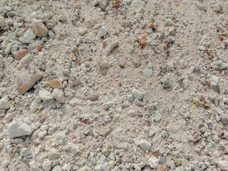Light-Colored Rocks and Pebbles on Dusty Ground Surface with Rough Texture