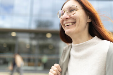 Fototapeta premium Happy businesswoman walking and smiling in urban city