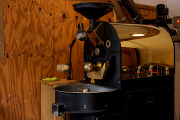 Large Industrial Coffee Roasting Machine With a Shiny Copper Finish Sits in a Cafe
