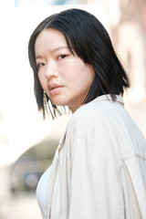 Young asian woman turning her head and looking over her shoulder