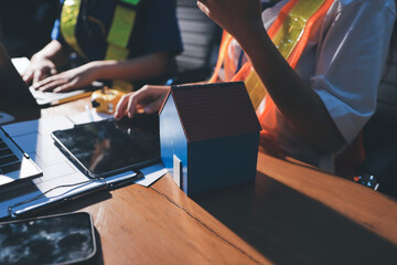 Closeup of team of industrial engineers meeting analyze machinery blueprints consult project on table in manufacturing factory. Working in manufacturing plant or production plant.