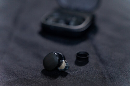 A pair of sleek black Fairphone Fairbuds, wireless true earbuds designed with sustainability in mind. The eco-friendly audio device combines modern minimalist design with high-quality sound, emphasizi