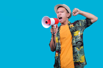 Excited Asian Man In Vacation Outfit Holding A Megaphone And Making A Triumphant Gesture on Blue...