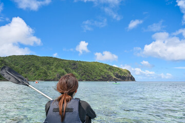 美しい沖縄の海を眺める女性の後ろ姿