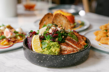 Grilled chicken salad bowl with avocado, beetroot, kale, and lemon