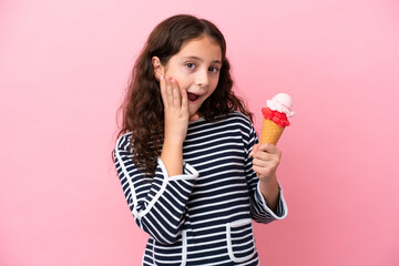 Little caucasian girl holding an ice cream isolated on pink background with surprise and shocked...