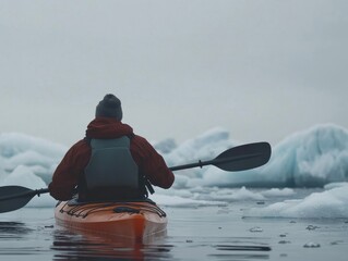 A lone kayaker navigates tranquil waters surrounded by majestic icebergs under overcast skies. The calm atmosphere enhances the beauty of the remote Arctic landscape.
