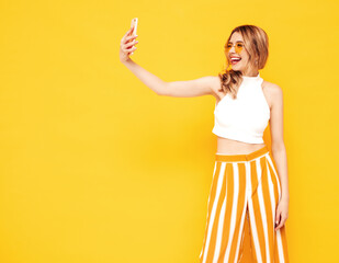 Portrait of young beautiful smiling blond female in trendy summer clothes. carefree woman posing...