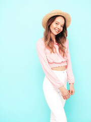 Young beautiful smiling female in trendy summer clothes. carefree woman posing near blue wall in...