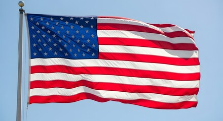 Obraz premium The american flag, a symbol of freedom and democracy, waves proudly in the wind against a clear blue sky, representing the united states of america