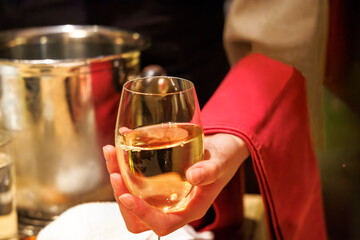 飲食店で、よく冷えた白ワインを注ぐ人