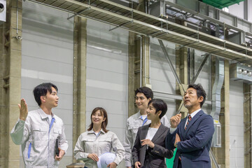 訪問者に工場を案内する作業員