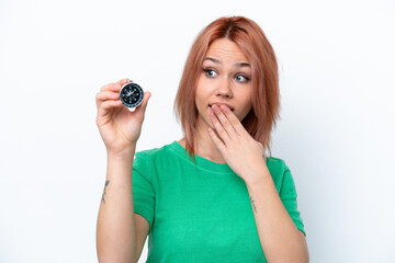 Young Russian girl holding compass isolated on white background with surprise and shocked facial...