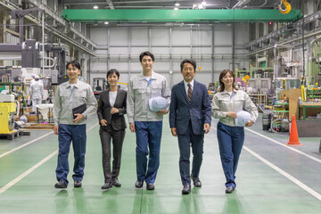 工場の中を歩く作業スタッフのグループ