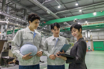 工場を視察する女性ビジネスパーソンと男性作業員