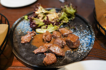 Close-Up of Black Pepper Beef Cubes with Kale on Dining Table – Savory and Healthy Meal