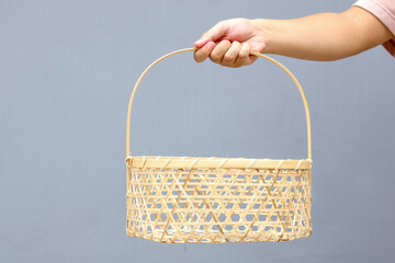 Hand holding handcrafted bamboo basket or woven bamboo basket