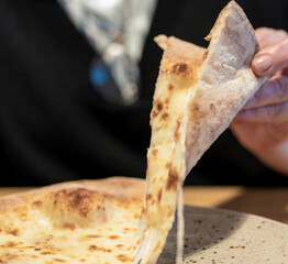 Appetizing pizza, four cheeses, holds a slice of pizza, and pulls cheese. for the restaurant and...