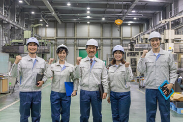 工場の中でガッツポーズする作業員