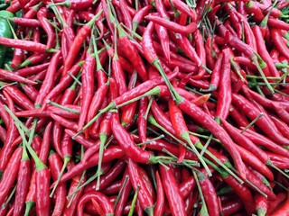 Fresh Red Chili Peppers with Green Stems in a Vibrant Pile