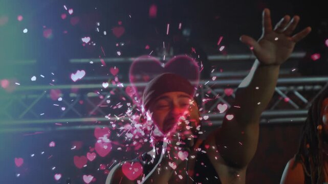 Animated red heart pulsing and shattering particles while singer raising arm and singing on stage