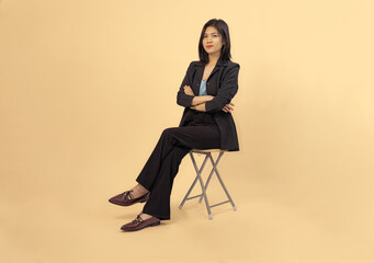 confident professional woman seated in business attire against neutral background