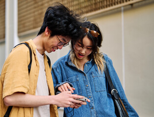 Portrait of a smiling couple walking down the street and taking picture in the city, tourists...