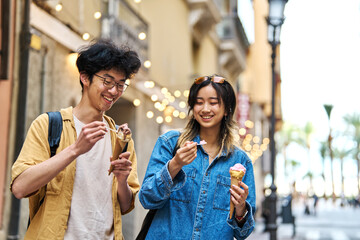 Portrait of a smiling couple in the city, tourists visiting destination, summer trip exploring and eating an ice cream
