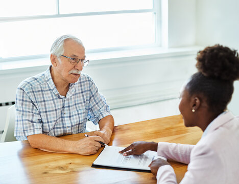 Happy senior old family couple clients make financial insurance estate business deal contract signing, agent lawyer, satisfied mature customers signing contract meeting bank manager agree on investmen