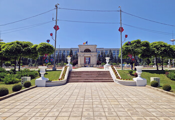 Fototapeta premium CHISINAU, MOLDOVA Triumphal Arch as popular historical landmark of the capital with the Moldovan Government House in the background