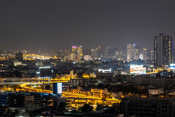 Obraz premium Blurred background of night lights in Bangkok. Fireworks, traffic lights, lights on bridges over the river, the spread of electric lighting technology in homes.