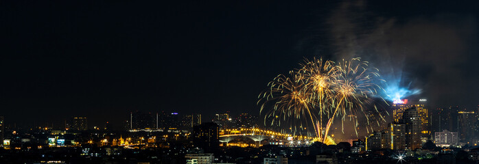 Blurred background of night lights in Bangkok. Fireworks, traffic lights, lights on bridges over the river, the spread of electric lighting technology in homes.