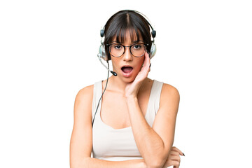 Telemarketer caucasian woman working with a headset over isolated background surprised and shocked...