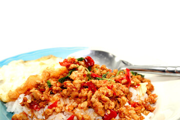 Rice with basil, minced pork, fried egg, delicious and spicy Thai food is popular all over the world, ready to be served to you on a white background.