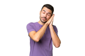 Fototapeta premium Young handsome caucasian man over isolated background making sleep gesture in dorable expression