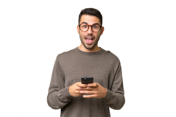 Young handsome caucasian man over isolated background surprised and sending a message