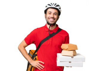 Young handsome caucasian man with thermal backpack and holding takeaway food over isolated background posing with arms at hip and smiling