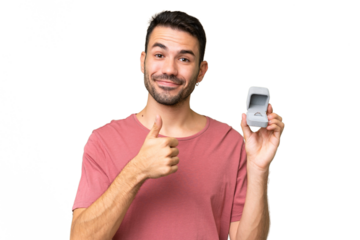 Young handsome caucasian man holding a engagement ring over isolated background with thumbs up because something good has happened