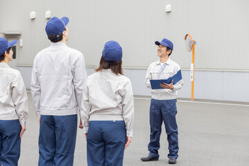 屋外でミーティングする作業員グループ