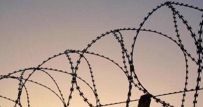 Background tracking shot of the cloudless sky over barbed wire for use in a composition for titles or titles, empty space for text or inscription.