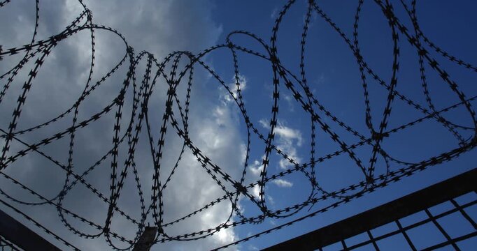 Background with clouds running in the sky over barbed wire for use in a composition for titles or titles, empty space for text or inscription.